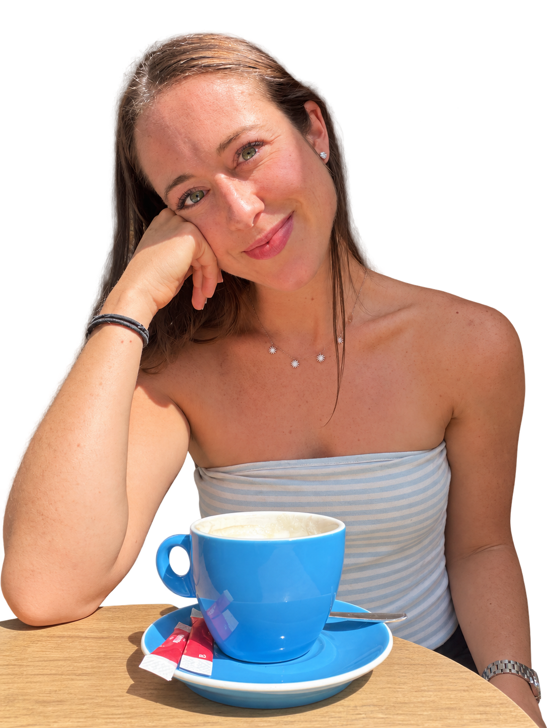 Brooke Robbins at a café, resting her cheek on her hand beside a blue coffee cup